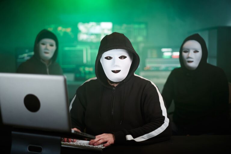 Cybersecurity professional smiling while creating an awareness meme on laptop