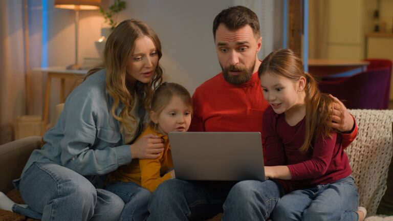 Parent teaching child safe internet habits on laptop with security icons